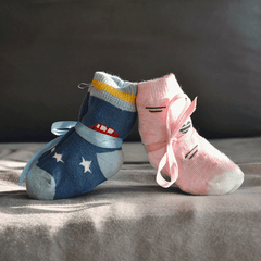 Babysocken Einstecker Add-on - It's a Girl - It's a Boy als liebevolles Accessoire für Blumen zur Geburt, kombiniert in Rosa und Blau mit Schleifen.