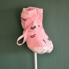 Rosa Babysocken Einstecker Add-on mit niedlichem Katzenmotiv und Schleife, ideal für Blumen zur Geburt eines Mädchens.
