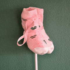 Rosa Babysocken Einstecker Add-on mit niedlichem Katzenmotiv und Schleife, ideal für Blumen zur Geburt eines Mädchens.