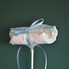 Einzelner Windel Einstecker mit blauer Schleife auf Stab, liebevolles Detail für Baby-Blumensträuße und Geschenkideen zur Geburt.