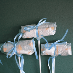 Drei Windel Einstecker mit blauen Schleifen auf Stäben, dekoratives Add-on für Baby It's a Boy Blumenversand zur Geburt.