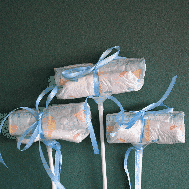 Drei Windel Einstecker mit blauen Schleifen auf Stäben, dekoratives Add-on für Baby It's a Boy Blumenversand zur Geburt.