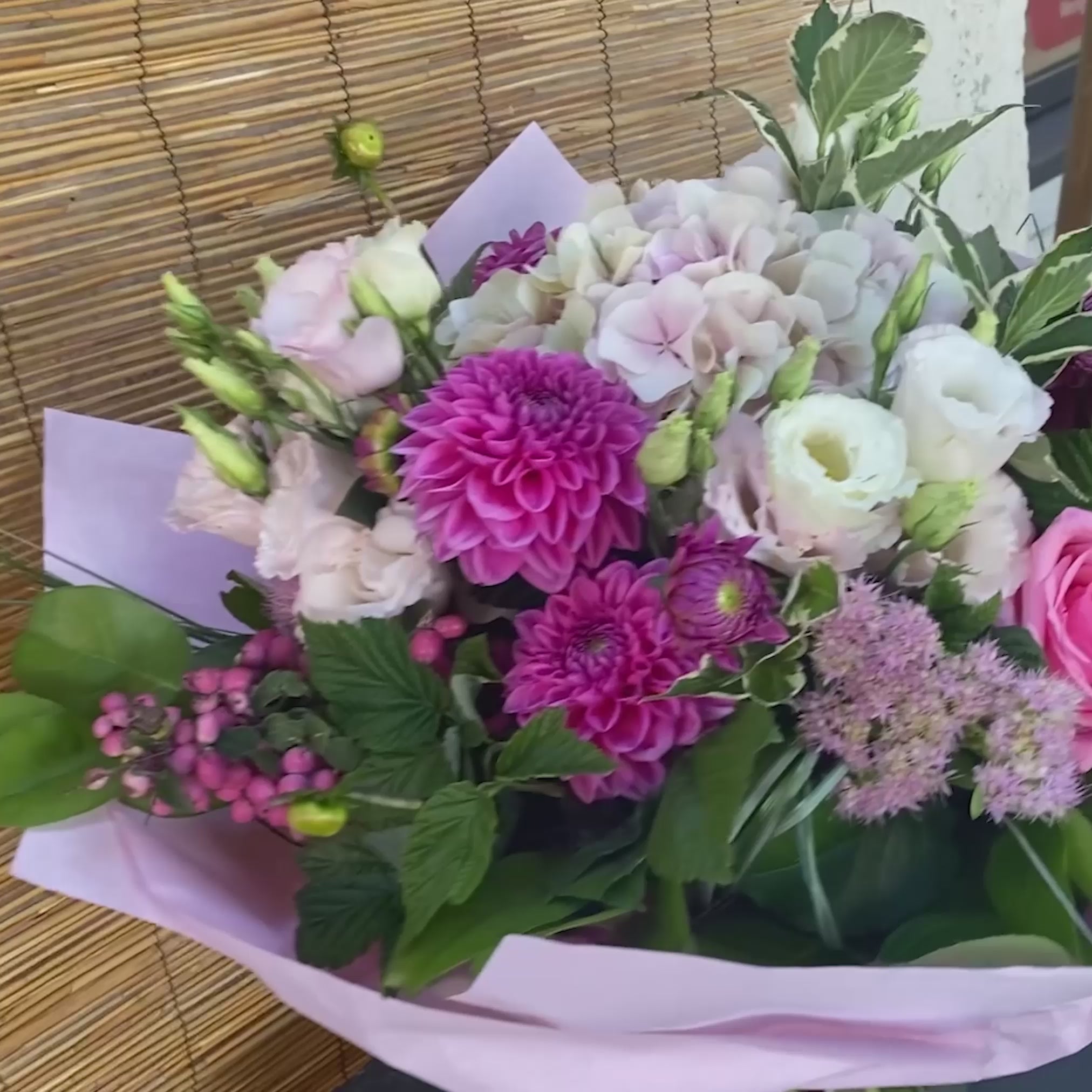 Romantischer rosa Blumenstrauß mit Rosen, Hortensien und Dahlien in verschiedenen Rosatönen