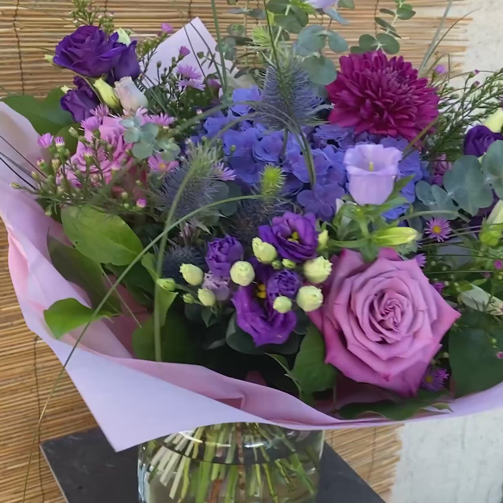 Üppiger lila Blumenstrauß mit violetten Hortensien, Rosen und lockerem Eukalyptus