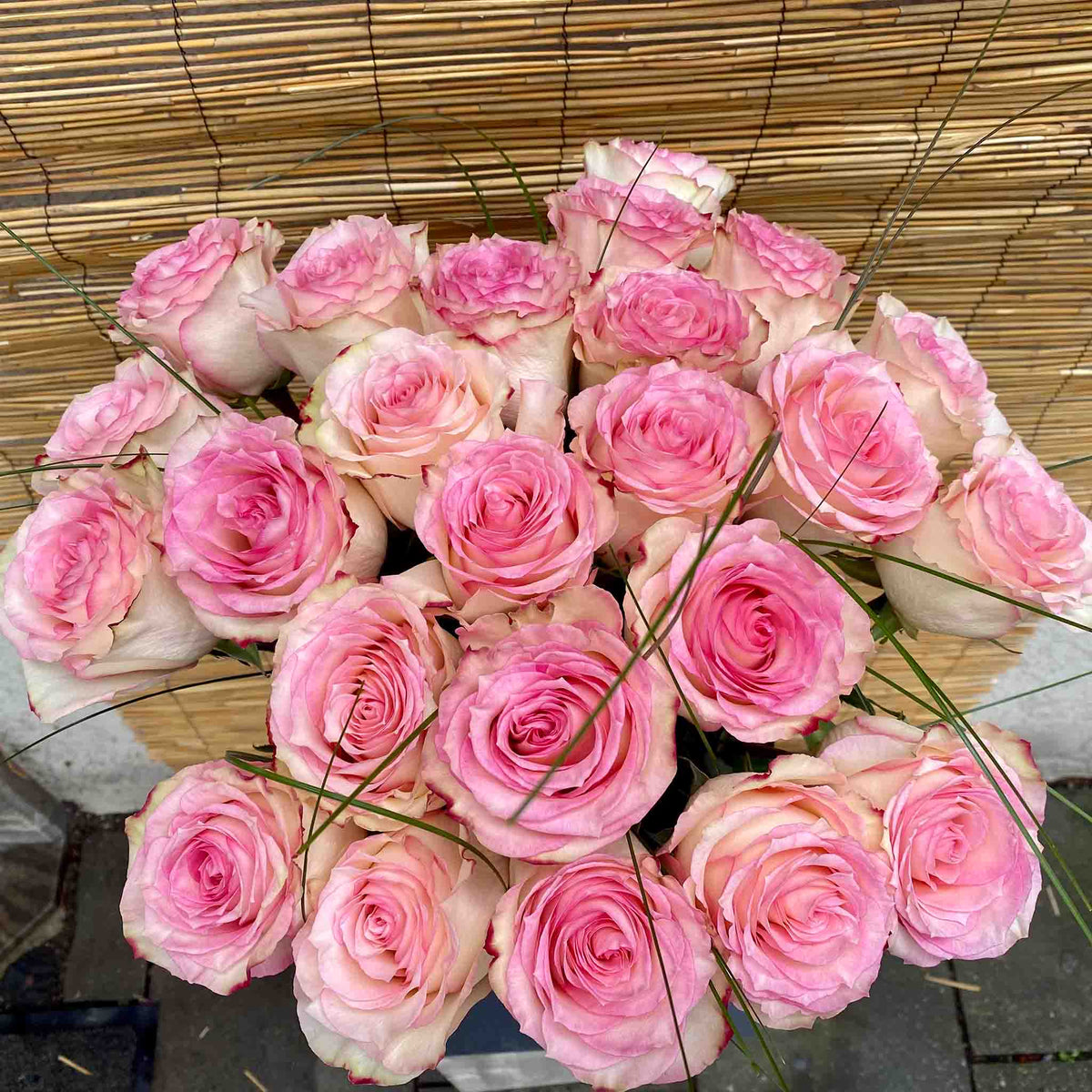 Pink Esperanza rose bouquet with cream petals and delicate green ornamental grasses