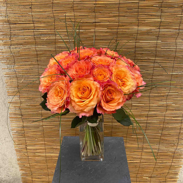 Orange Rosen stilvoll arrangiert in einer Vase