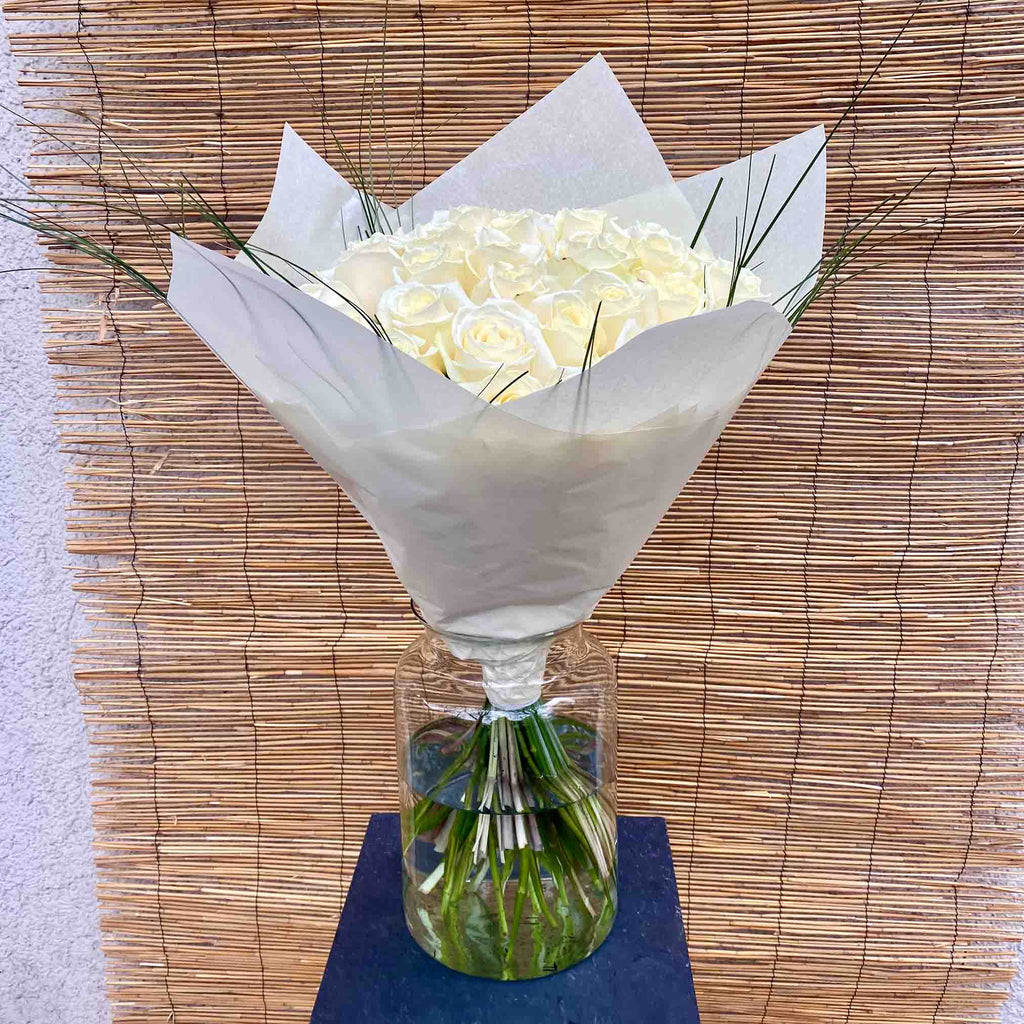 Elegant bouquet of white roses with delicate green ornamental grasses