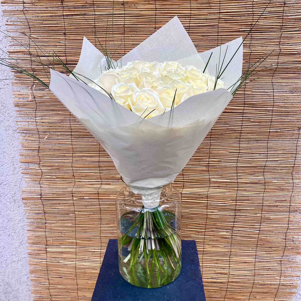 Elegant bouquet of white roses with delicate green ornamental grasses