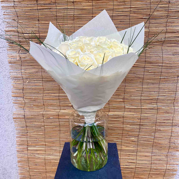 Elegant bouquet of white roses with delicate green ornamental grasses