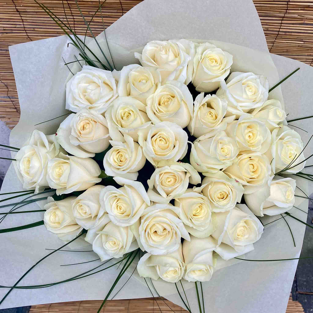 Eleganter Strauß aus weißen Rosen mit feinen grünen Ziergräsern